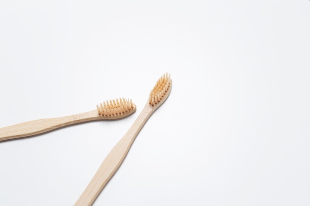 Primer plano de dos cepillos de dientes de bambú sobre fondo blanco de estudio