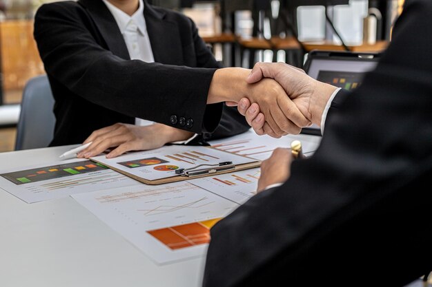 Primer plano dos hombres de negocios tomados de la mano, dos hombres de negocios acuerdan negocios juntos y se dan la mano después de una negociación exitosa. El apretón de manos es un saludo o felicitación occidental.