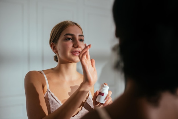 Primer plano de dos mujeres aplicándose crema en la cara