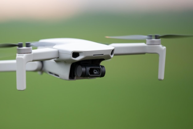 Primer plano de un dron volando en el campo verde Nuevo quadcopter en uso grabando video en buena calidad