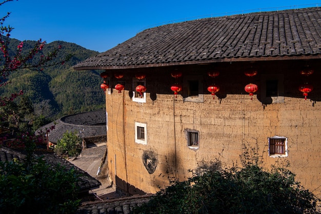 Primer plano del edificio Tulou en el grupo de Tulou de Tianluokeng Fujian China Cielo azul linternas tradicionales chinas