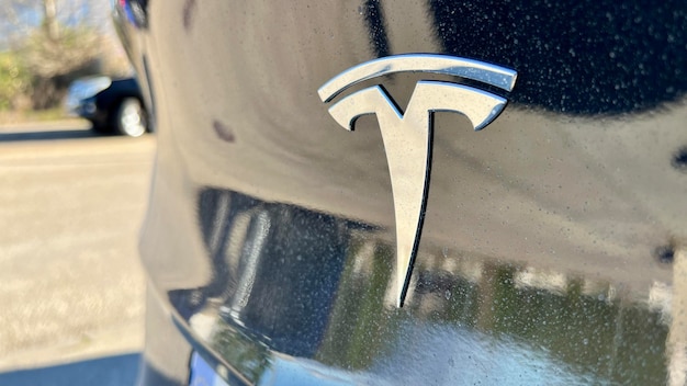 Un primer plano del emblema del automóvil Tesla en el capó