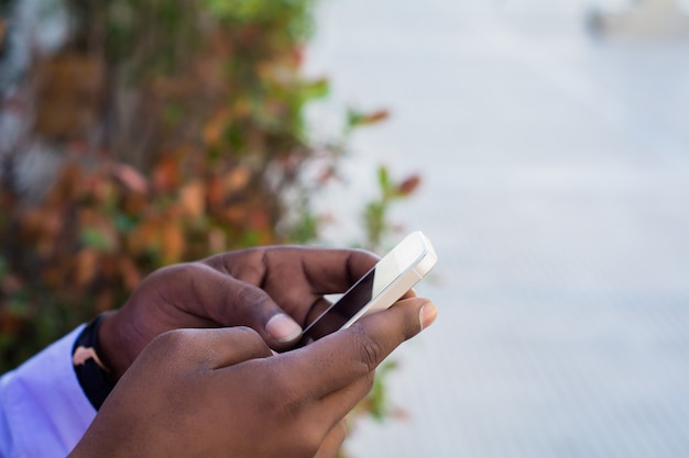 Primer plano del empresario con su teléfono móvil al aire libre en la calle. Concepto de negocio.