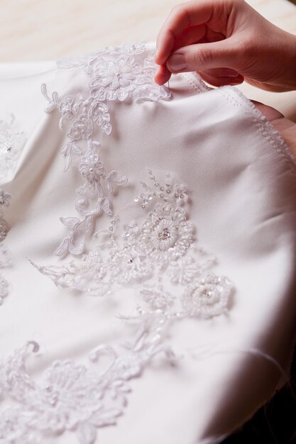 Foto primer plano de encaje a mano en el vestido de novia