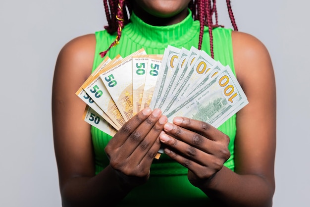 Foto primer plano enfocado selectivamente mujer afroamericana sosteniendo billetes de dólares billete de un montón de dinero