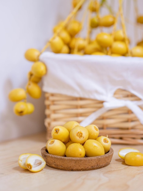 Foto en primer plano y enfoque selectivo frutas frescas de dátiles en plato de madera