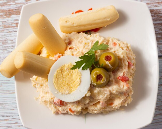 Foto primer plano de ensalada rusa en un plato blanco