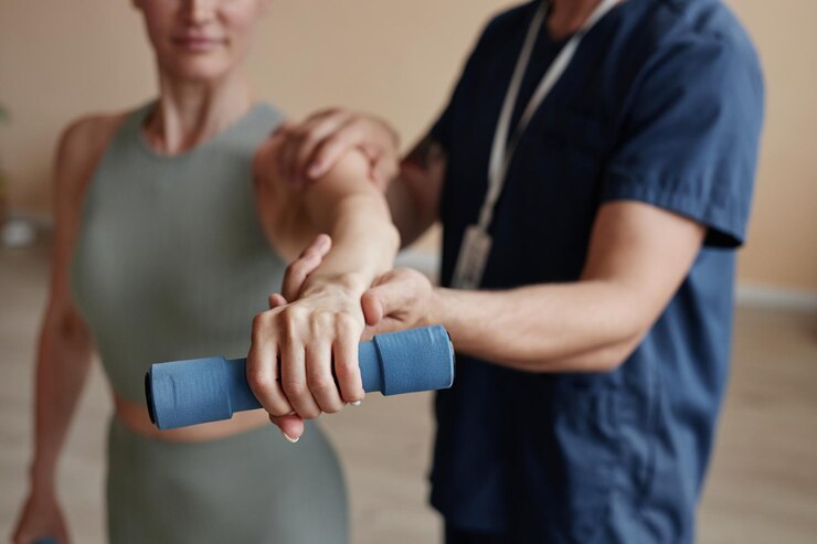 Primer plano del entrenamiento del paciente con pesas junto con el terapeuta en el hospital