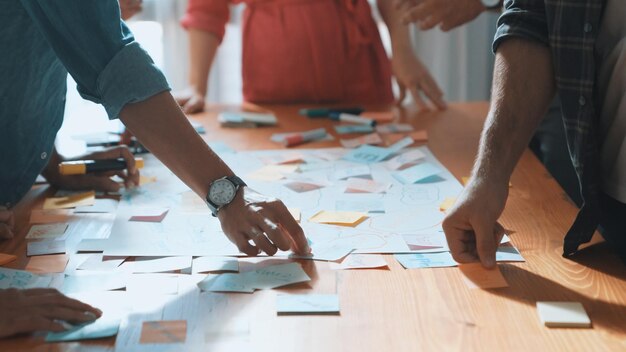 Un primer plano de un equipo de desarrolladores inteligentes que utiliza un mapa mental para hacer una tormenta de ideas en un simposio