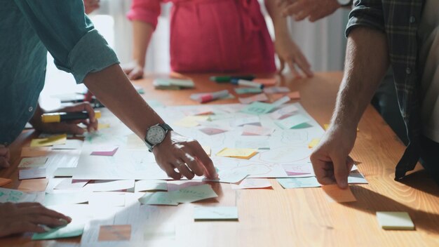 Un primer plano de un equipo de desarrolladores inteligentes usando un mapa mental para una tormenta de ideas Simposio