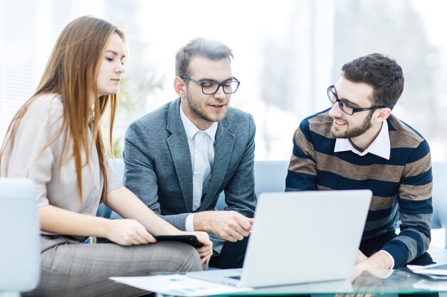 Primer plano de un equipo empresarial exitoso con un portátil en el lugar de trabajo discutir cuestiones de trabajo