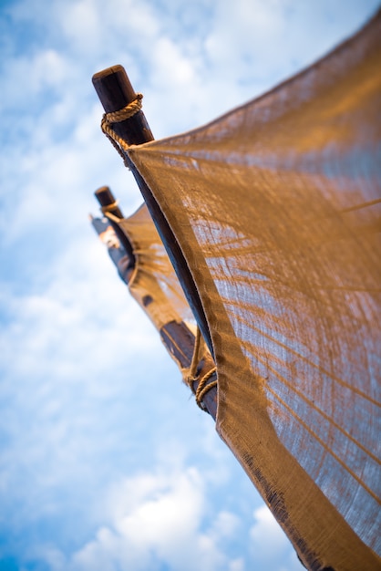 Primer plano es un nudo de madera entretejido con una cuerda en el mástil del barco en el contexto de un soleado cielo azul cálido en un día de verano. Concepto en el tema marino. Espacio publicitario