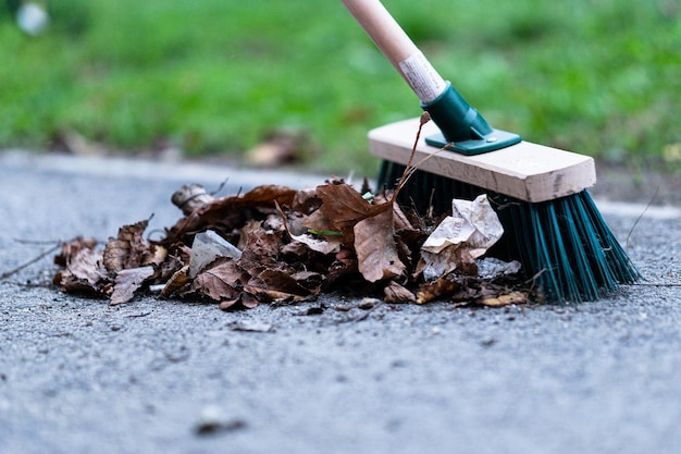 Primer plano de una escoba calle verde utilizada en la limpieza de un pavimento