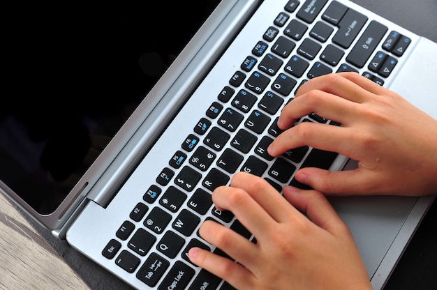 Primer plano de escribir manos femeninas en el teclado