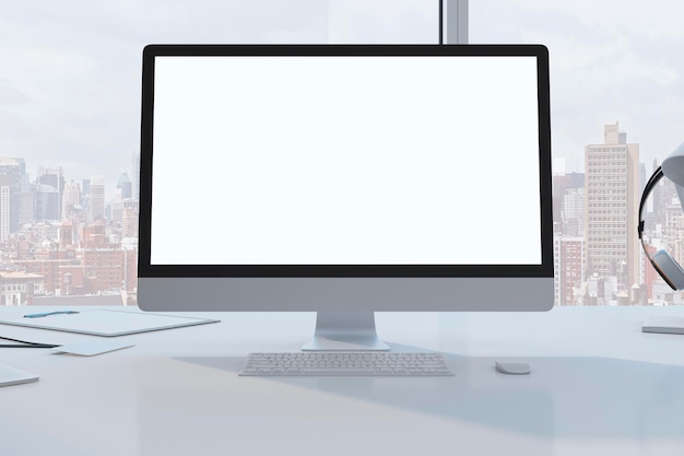 Primer plano del escritorio de diseñador con un monitor de computadora blanco vacío y suministros en una oficina moderna con ventana y vista panorámica de la ciudad Representación 3D