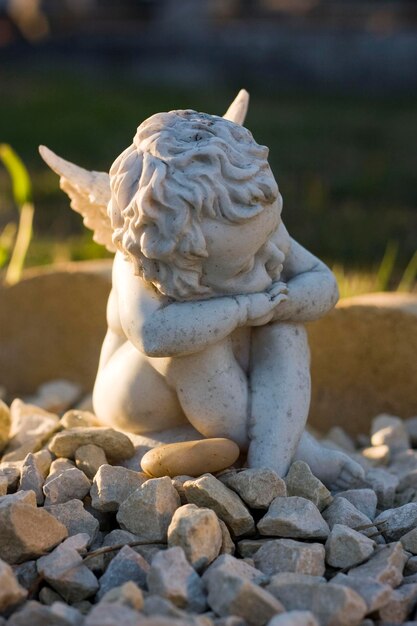 Primer plano de la escultura de un ángel en las gravas del cementerio