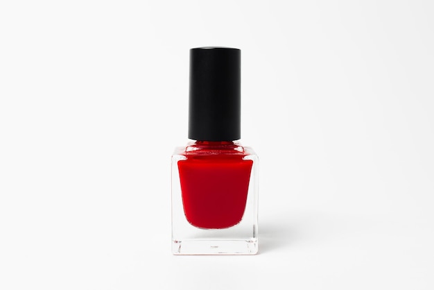 Primer plano de esmalte de uñas glitter de color rojo aislado sobre fondo blanco.