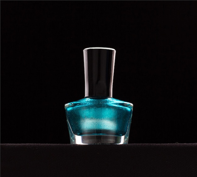 Primer plano de esmalte de uñas en la mesa contra un fondo negro