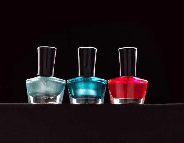 Primer plano de esmalte de uñas en la mesa contra un fondo negro