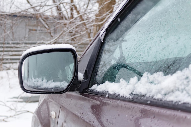 Primer plano del espejo lateral SUV cubierto de nieve. coches en invierno