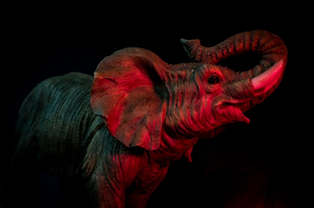 Primer plano de una estatua de elefante contra un fondo negro