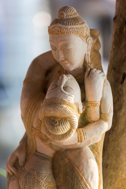 Primer plano de estatuas de madera jemer de amantes con fondo borroso