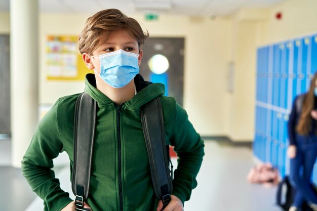 Foto un primer plano de un estudiante con una máscara de protección en la escuela