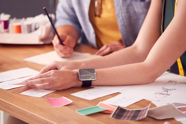 Primer plano de estudiantes masculinos y femeninos o dueños de negocios que trabajan en diseños en Fashion Studio