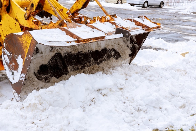 Primer plano de una excavadora para remoción de nieve en un estacionamiento cubierto de nieve cubierto después de una tormenta de nieve