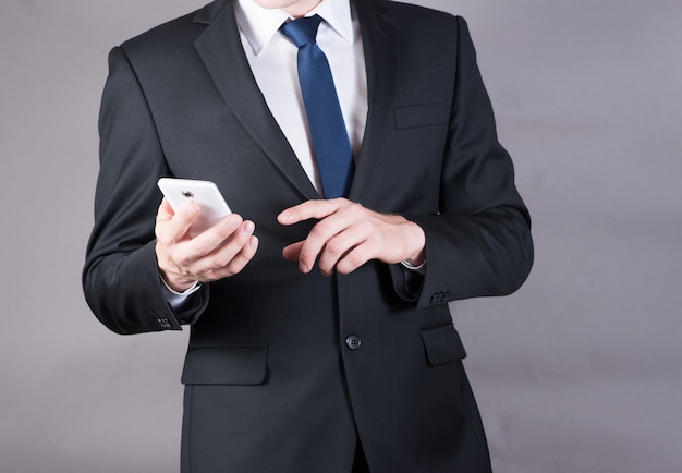 Primer plano de un exitoso hombre de negocios usando teléfono móvil inteligente