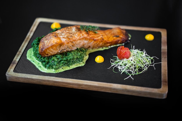 Primer plano de una exquisita porción de un plato especial del chef en una pizarra negra