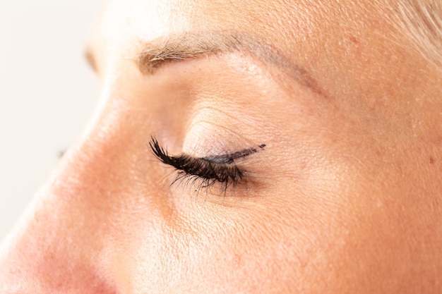 Primer plano extremo del ojo cerrado femenino con maquillaje ligero todos los días