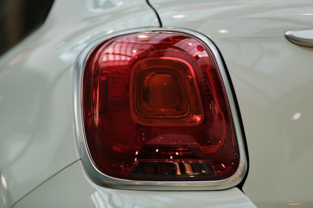 primer plano de faro rojo en un automóvil blanco