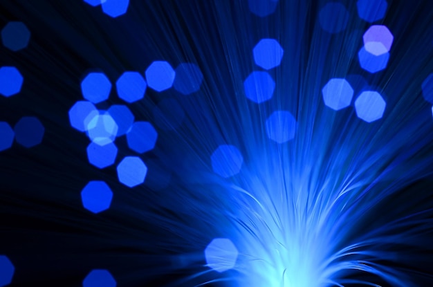 Primer plano de fibra óptica iluminada contra un fondo negro