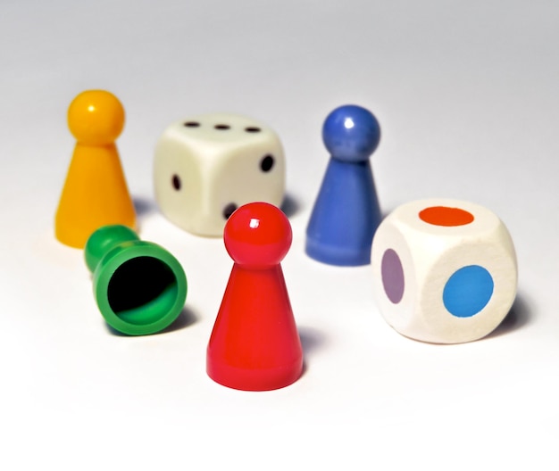 Primer plano de fichas de ludo coloridas con dados en fondo blanco