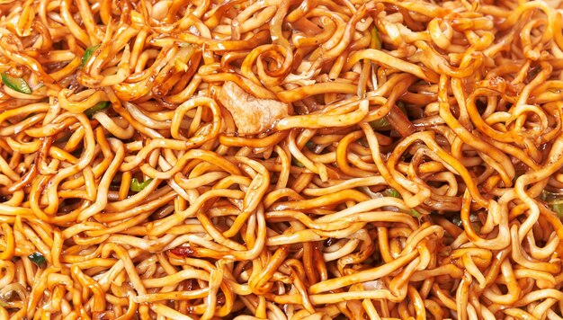 Un primer plano de fideos de pollo tailandeses con verduras frescas