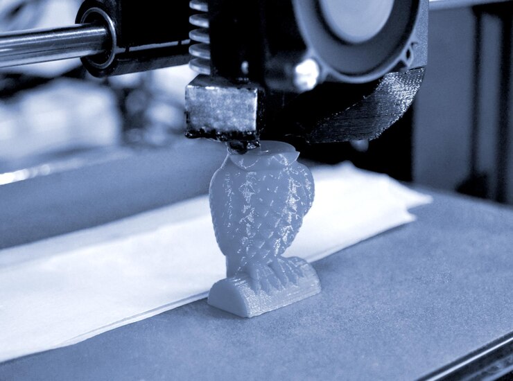 Foto primer plano de figura de impresión de impresora 3d moderna. la impresora 3d tridimensional automática realiza el modelado de colores amarillos plásticos en el laboratorio. tecnología aditiva moderna y progresiva. color gris azul