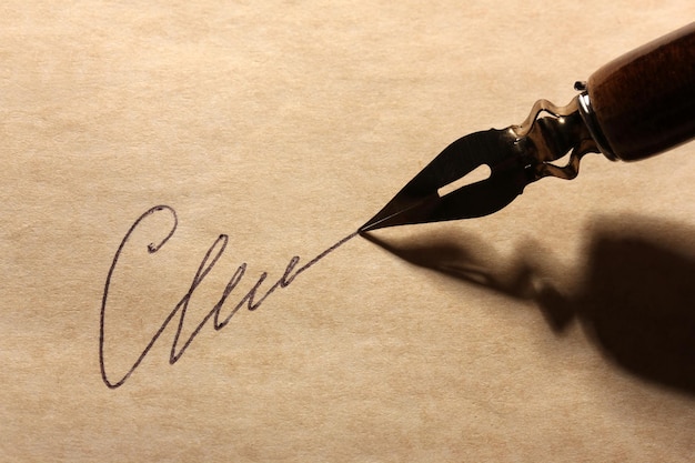 Primer plano de firma falsa no real y pluma de tinta en papel antiguo