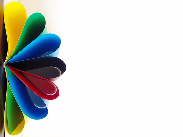 Primer plano de una flor de papel colorida contra un fondo blanco