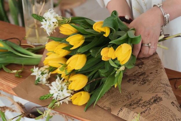 primer plano de floristería haciendo ramo de tulipanes amarillos en floristería