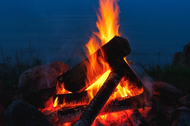 Primer plano de una fogata al aire libre que arde brillantemente por la noche