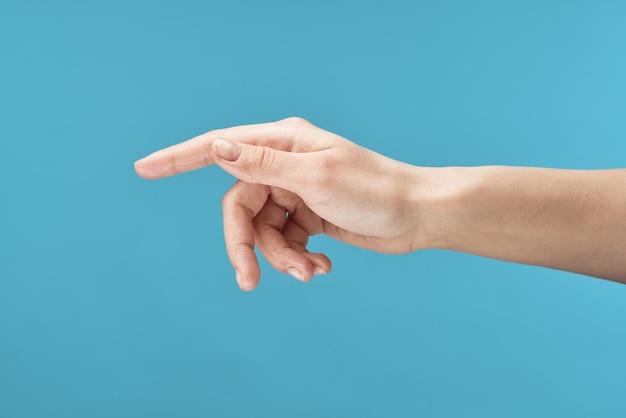 Foto primer plano de fondo azul crema para el cuidado de la piel de la mano femenina