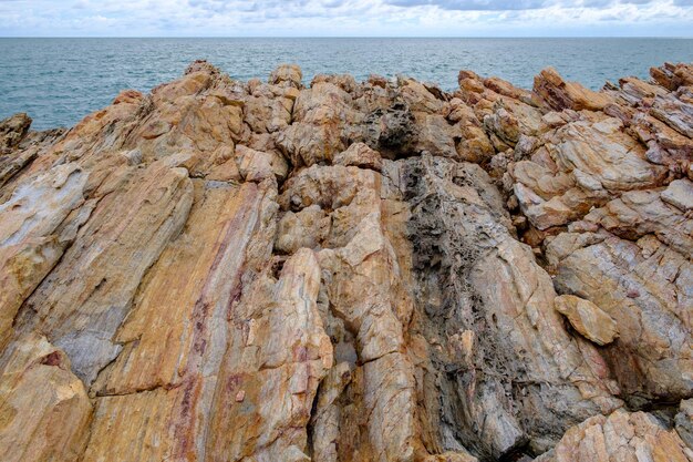 Foto primer plano de la formación rocosa en la playa contra el cielo