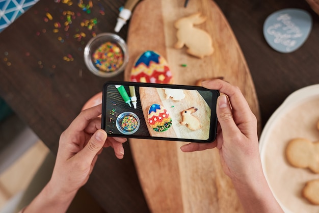 Primer plano de la foto en el teléfono móvil de galletas de jengibre preparadas para la Pascua
