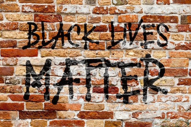 Primer plano de la frase Black Lives Matter pintada en una pared de ladrillos