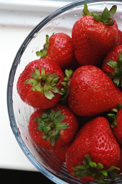 primer plano de fresas frescas en un recipiente con agua