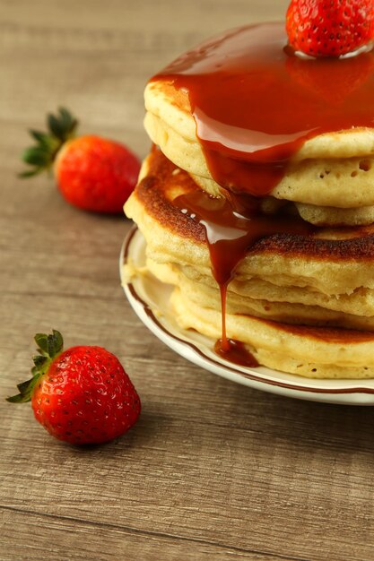 Foto primer plano de fresas y panqueques en un plato sobre la mesa