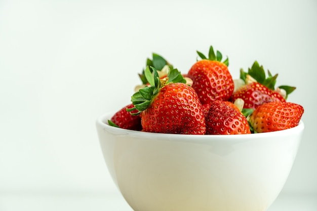 Foto primer plano de fresas rojas en un recipiente blanco