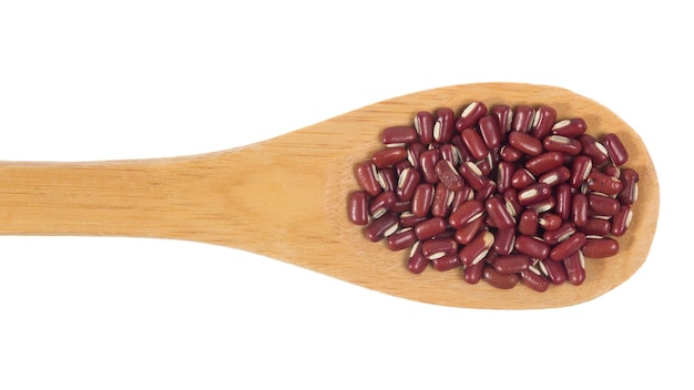 Primer plano de frijoles en una cuchara de madera sobre un fondo blanco