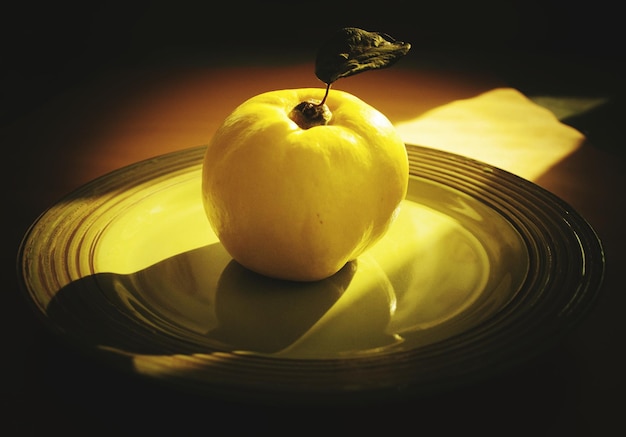 Primer plano de una fruta amarilla en un plato sobre la mesa